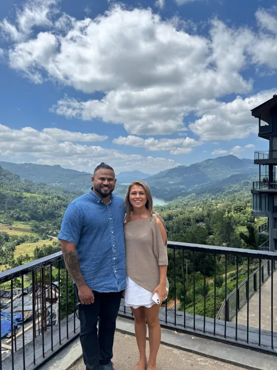 Travellers on a balcony overlooking green mountains
