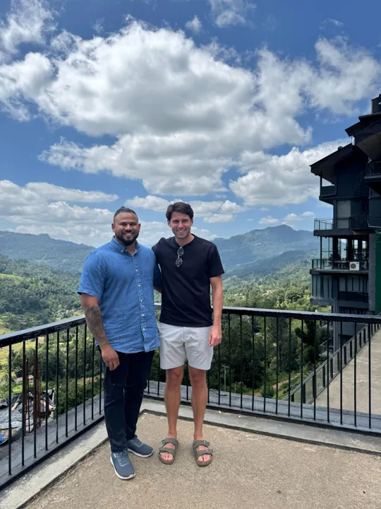 Travellers together on a balcony overlooking mountains