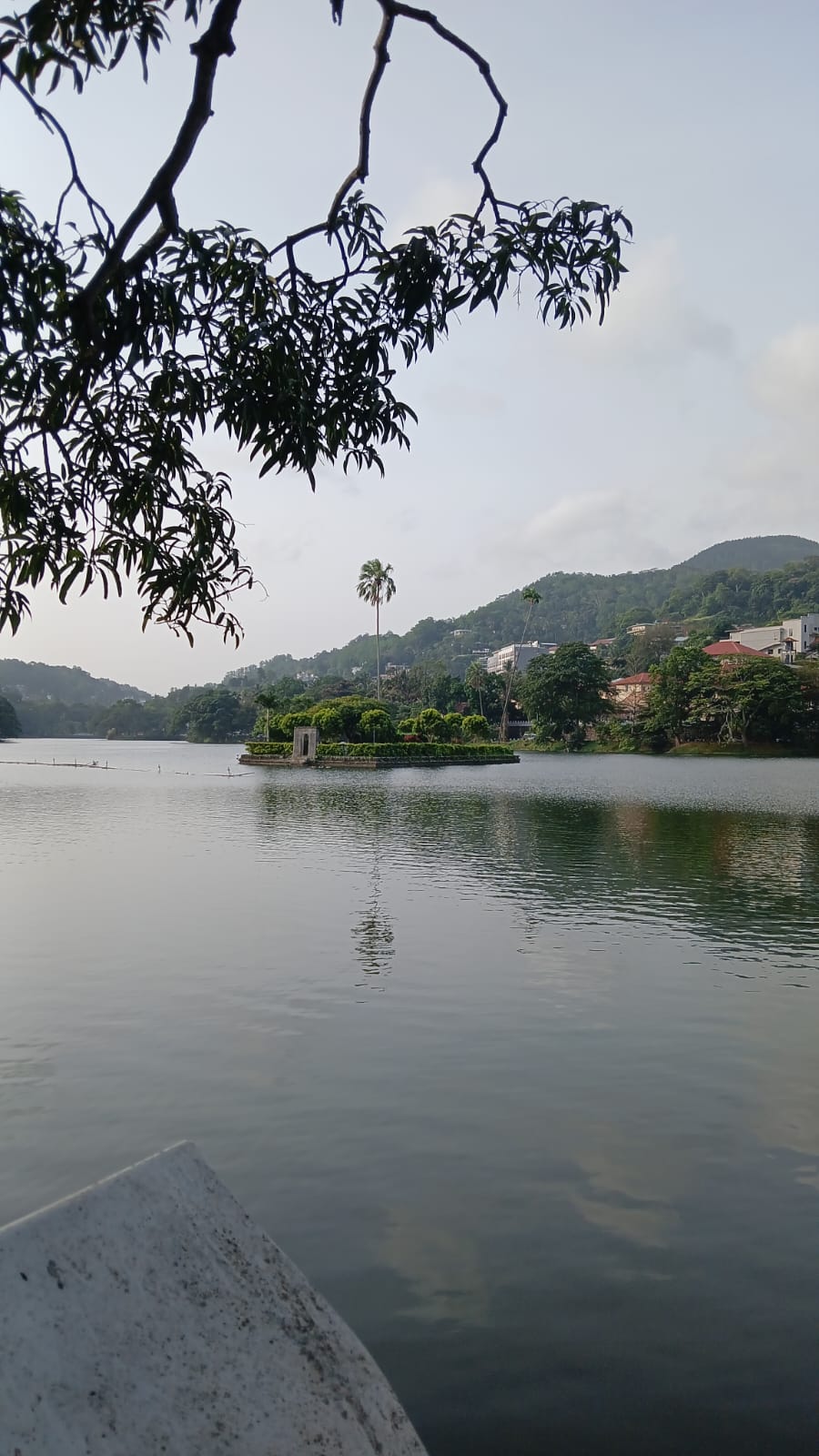 Kandy Lake with its small island and green hills beyond.