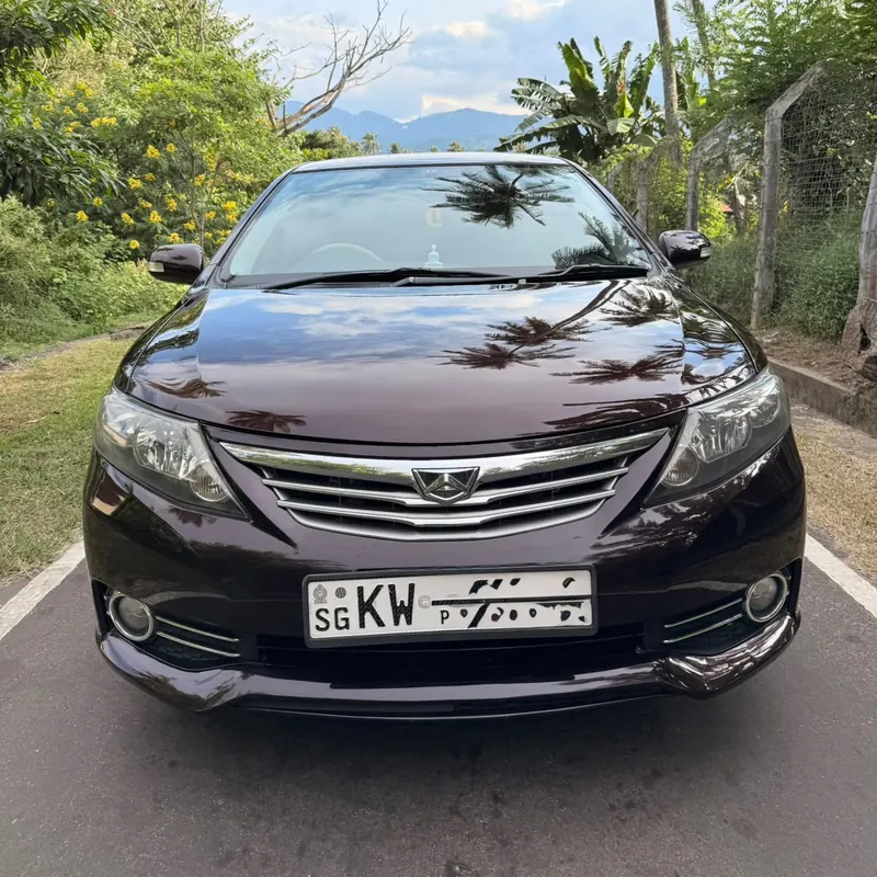 Toyota Allion — front of the dark-coloured car on a palm-lined road